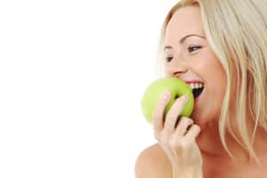 blond woman eat green apple